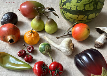 Collection of porcelain fruits & veggies on a table