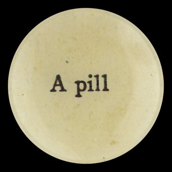 The words A Pill written on a decoupage four inch round plate handmade in our New York City studio